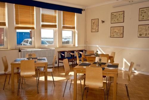 - une salle à manger avec des tables, des chaises et des fenêtres dans l'établissement The Aqua, à Portland