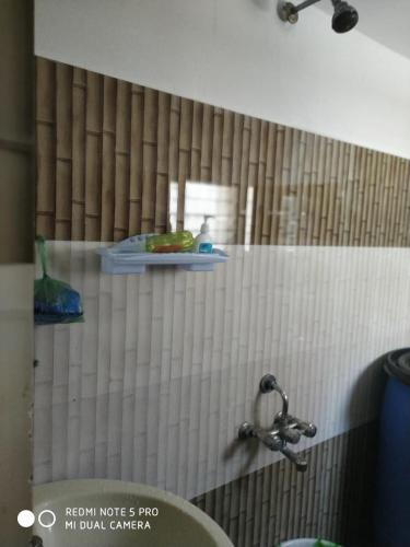 a bathroom with a shower with a sink and a shelf at The coloursinn Home stays in Chennai