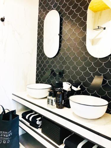 a bathroom with two sinks and a mirror on a shelf at Casa Rural Idesign in Villanueva de Ávila
