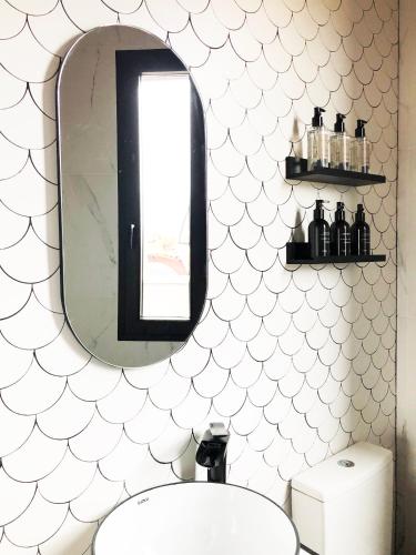 a bathroom with a mirror and a sink at Casa Rural Idesign in Villanueva de Ávila