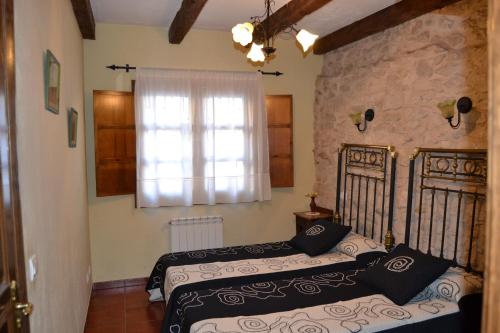 1 dormitorio con 2 camas y ventana en Casa Rural La Hontanilla, en Canalejas de Peñafiel