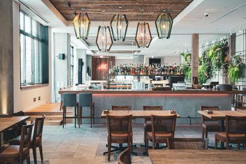 a restaurant with tables and chairs and a bar at Hotel It Osaka Shinmachi in Osaka