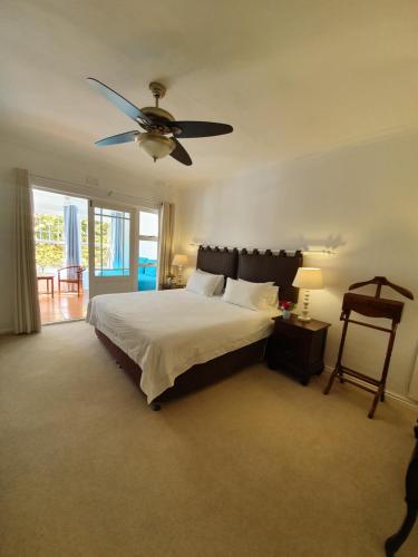 a bedroom with a bed with a ceiling fan at Paradiso Guesthouse & Self-catering Cottage in Cape Town
