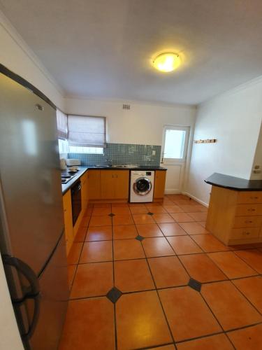 a kitchen with a tile floor and a washer and dryer at Paradiso Guesthouse & Self-catering Cottage in Cape Town