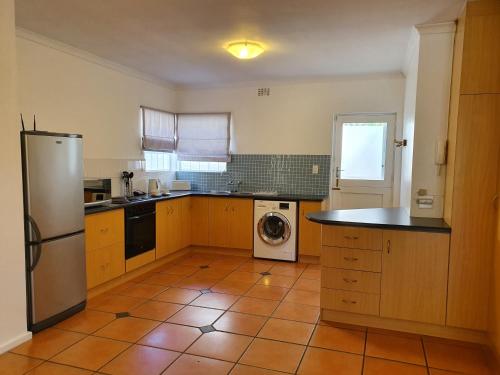 a kitchen with a refrigerator and a washing machine at Paradiso Guesthouse & Self-catering Cottage in Cape Town