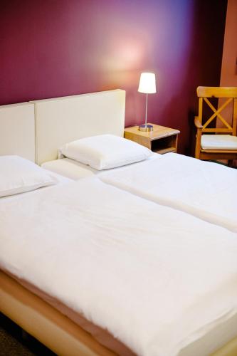 two beds in a bedroom with a purple wall at B&B De Vroling in Wellen