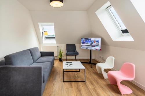 a living room with a couch and a tv at Lake House Plön in Plön