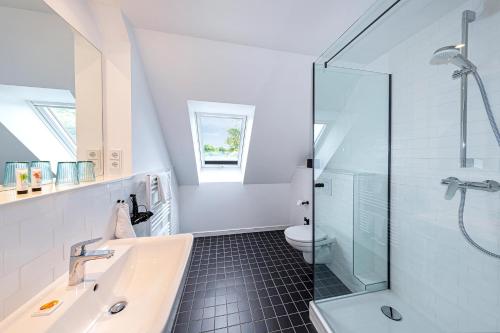 uma casa de banho com um lavatório, um chuveiro e um WC. em Lake House Plön em Plön