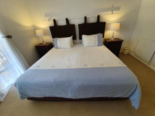 a bedroom with a large bed with white sheets and pillows at Paradiso Guesthouse & Self-catering Cottage in Cape Town