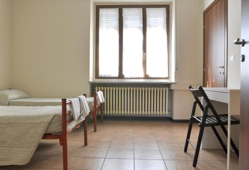 a room with a bed and a window at Ostello Cuneo in Cuneo