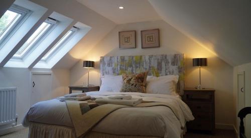 a bedroom with a large bed with two windows at Orford Lodge Barn in Orford