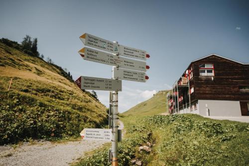a pole with street signs on a dirt road at Hotel Adler in Warth am Arlberg