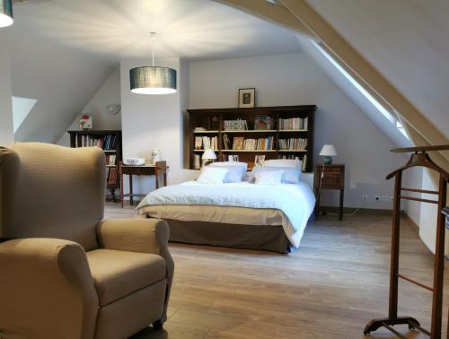 1 dormitorio con 1 cama, 1 silla y una escalera en Au jardin de Grand-Père, en Fougères-sur-Bièvre