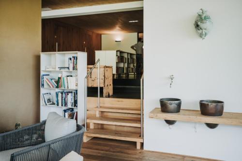 a living room with a book shelf and stairs at Hotel Adler in Warth am Arlberg