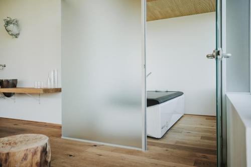 a bathroom with a sliding glass door and a sink at Hotel Adler in Warth am Arlberg