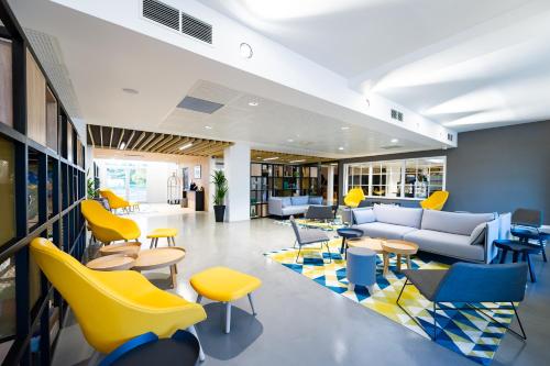 an office with yellow and blue chairs and tables at Staycity Aparthotels near Disneyland Paris in Bailly-Romainvilliers