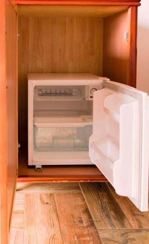 an open refrigerator with its door open in a kitchen at Fort Fun City Hotel Fort Portal in Fort Portal