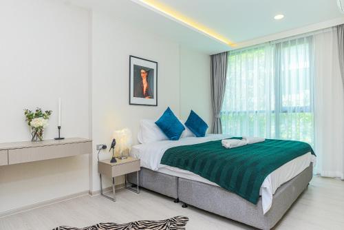 a bedroom with a large bed with blue pillows at Navi Vt-ara36 Condo in Bangkok