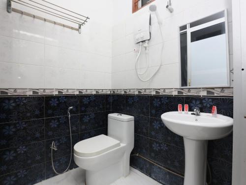 a bathroom with a toilet and a sink at Super OYO 89435 Nusantara Group Hotel in Jertih