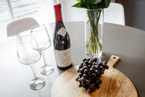 a bottle of wine and a bunch of grapes on a table at Dollar Apartments-41 Bridge Street in Dollar