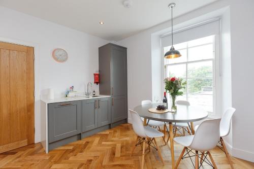 a kitchen with a table and chairs and a window at Dollar Apartments-41 Bridge Street in Dollar
