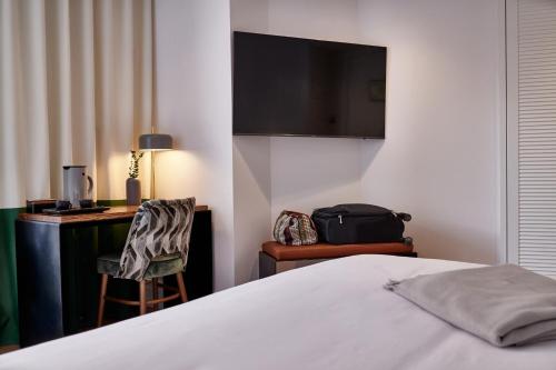 a bedroom with a bed and a television at Cosmo Hotel Boutique in Valencia