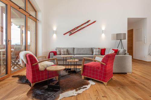 a living room with red chairs and a couch at Skylodge Alpine Homes in Haus im Ennstal