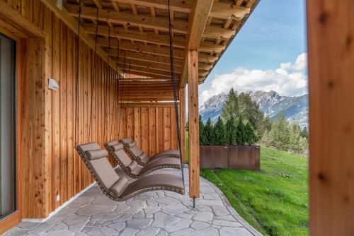 a group of benches sitting on the porch of a house at Skylodge Alpine Homes in Haus im Ennstal