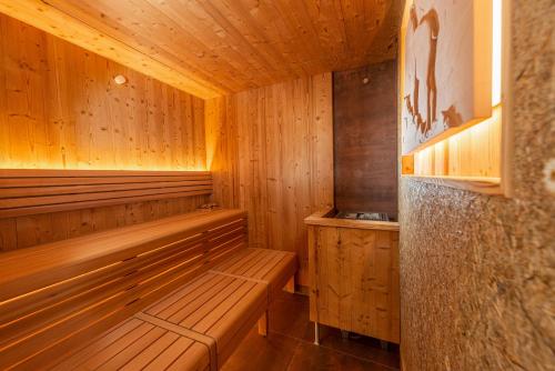 a wooden sauna with wooden benches in a room at Skylodge Alpine Homes in Haus im Ennstal