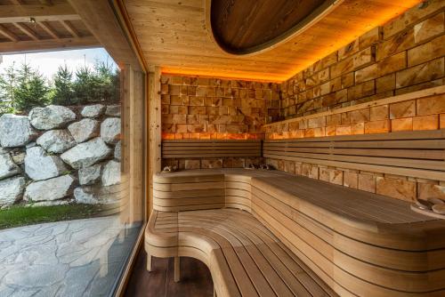 a wooden sauna with a bench in a stone wall at Skylodge Alpine Homes in Haus im Ennstal