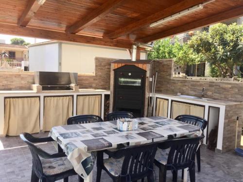 una cucina all'aperto con tavolo e sedie su un patio di Villa Giulia ad Alcamo Marina