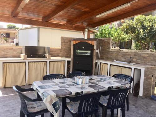 an outdoor kitchen with a table and chairs on a patio at Villa Giulia in Alcamo Marina