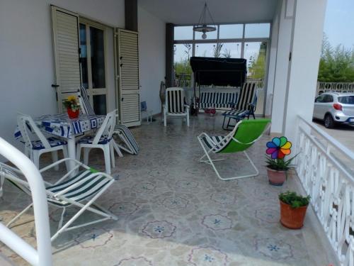 a porch with chairs and a table and a piano at Villa Giulia in Alcamo Marina