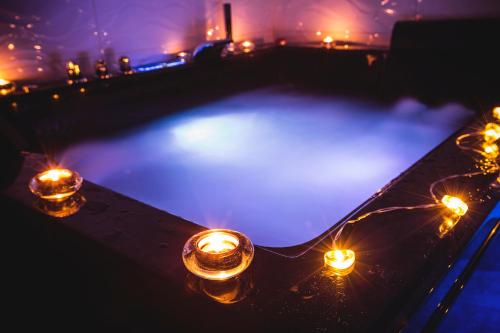 una piscina con velas y luces por la noche en Suite del Amore, en Babilafuente