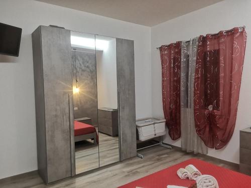 a room with a red bed and a glass door at R&B mediterraneo in Bosa