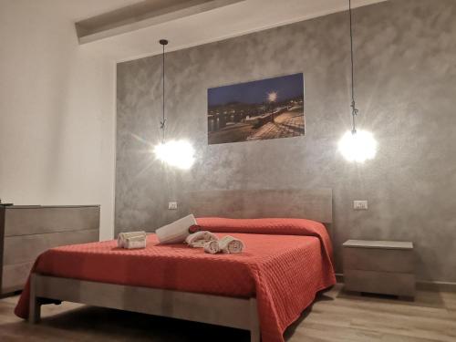a bedroom with a bed with a red blanket and two lights at R&B mediterraneo in Bosa