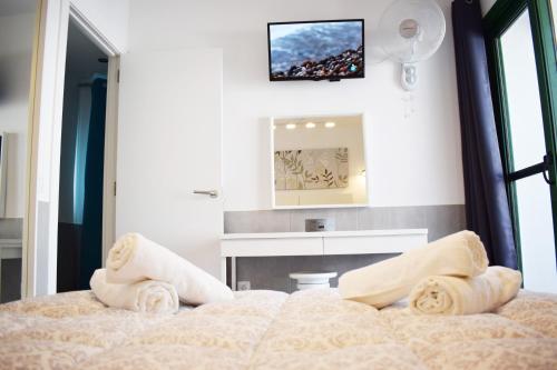 コラレホにあるHoliday Urbanのベッドルーム1室(ベッド1台、壁掛けテレビ付)