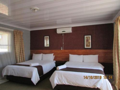 Postel nebo postele na pokoji v ubytování Aloes Lodge