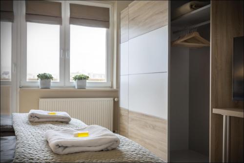 dwa ręczniki na łóżku w pokoju w obiekcie P&O Serviced Apartments NOWOGRODZKA w Warszawie