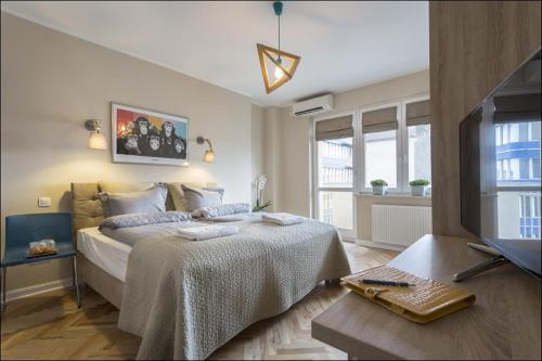 sypialnia z łóżkiem i telewizorem w pokoju w obiekcie P&O Serviced Apartments NOWOGRODZKA w Warszawie