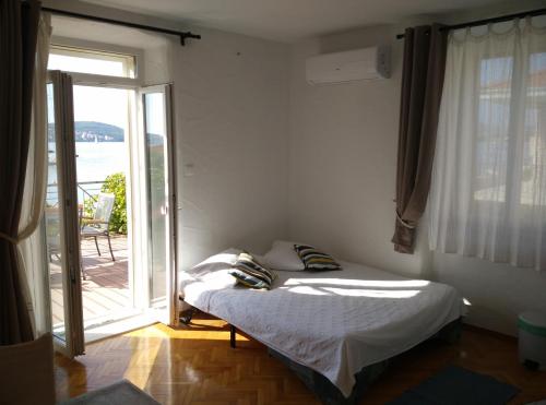 1 dormitorio con 1 cama y puerta corredera de cristal en Apartments Gina en Trogir