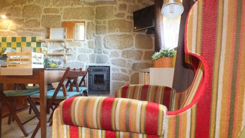 a living room with a chair and a stone wall at Quinta do Caritel in Vouzela