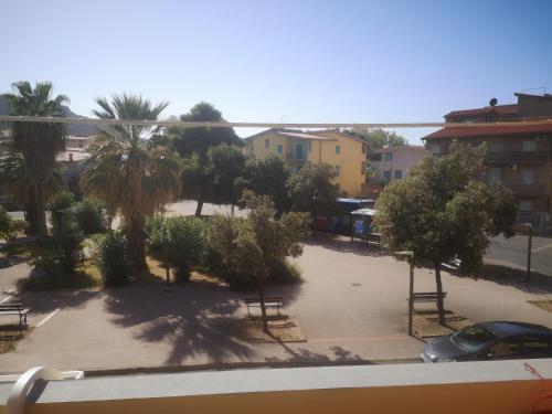 a view of a parking lot with trees and benches at R&B mediterraneo in Bosa