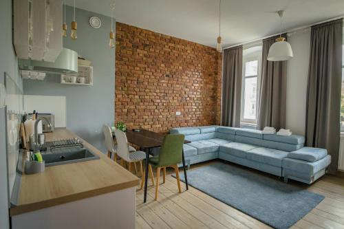 salon z niebieską kanapą i ceglaną ścianą w obiekcie Apartamenty Vilda w Poznaniu