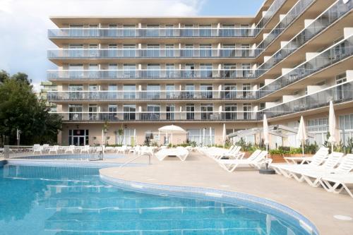 an apartment building with a swimming pool and lounge chairs at Aparthotel Cye Holiday Centre in Salou