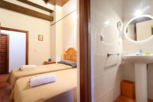 AdamuzにあるCasa Rural Finca Los Conventos en Adamuz CORDOBAのバスルーム(ベッド2台、シンク、鏡付)