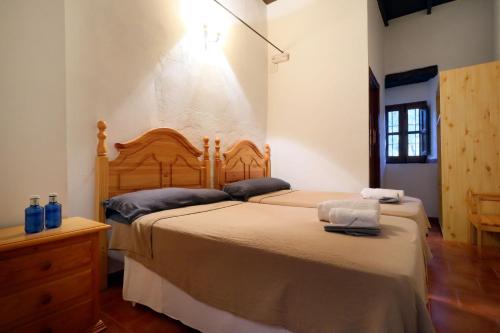 Casa Rural Finca Los Conventos en Adamuz CORDOBA في Adamuz: غرفة نوم بسريرين و اللوح الأمامي خشبي