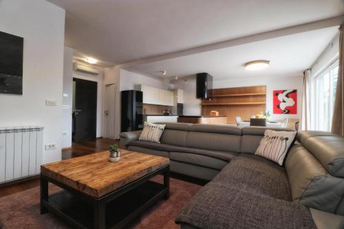 uma sala de estar com um sofá e uma mesa em Kseni Accommodation em Rovinj