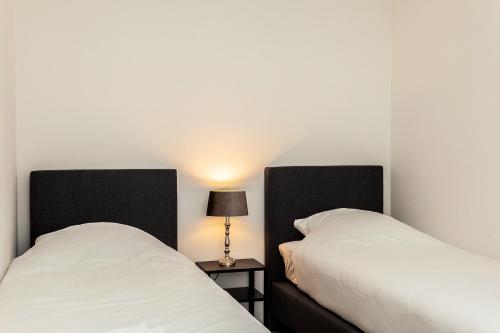 a hotel room with two beds and two lamps at Museumpark Apartments in Rotterdam