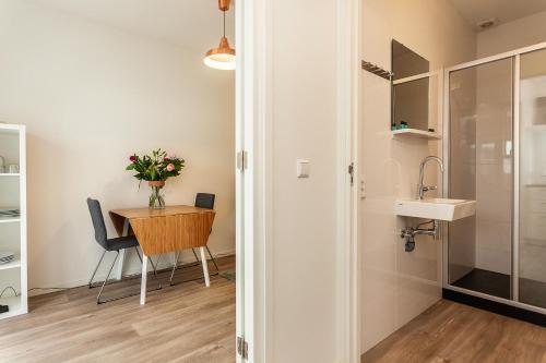 Habitación pequeña con mesa y lavamanos en Museumpark Apartments en Róterdam